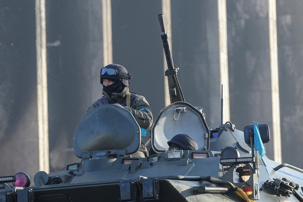 A Kazakh soldier in an armoured vehicle outside the Almaty city administration headquarters, which was set on fire during recent protests, Photo: Reuters