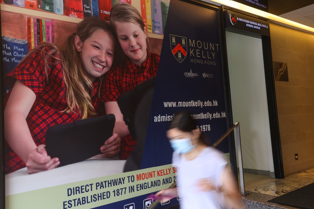 A woman walks past a Mount Kelly poster outside its Tsim Sha Tsui school on June 15 last year. The former operator of Mount Kelly accumulated millions in debt. Photo: K. Y. Cheng