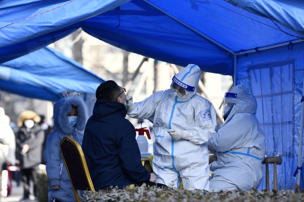 Protected workers test a man in Tianjin as the city suffers a rise in Omicron cases ahead of the Winter Olympics. Photo: AP