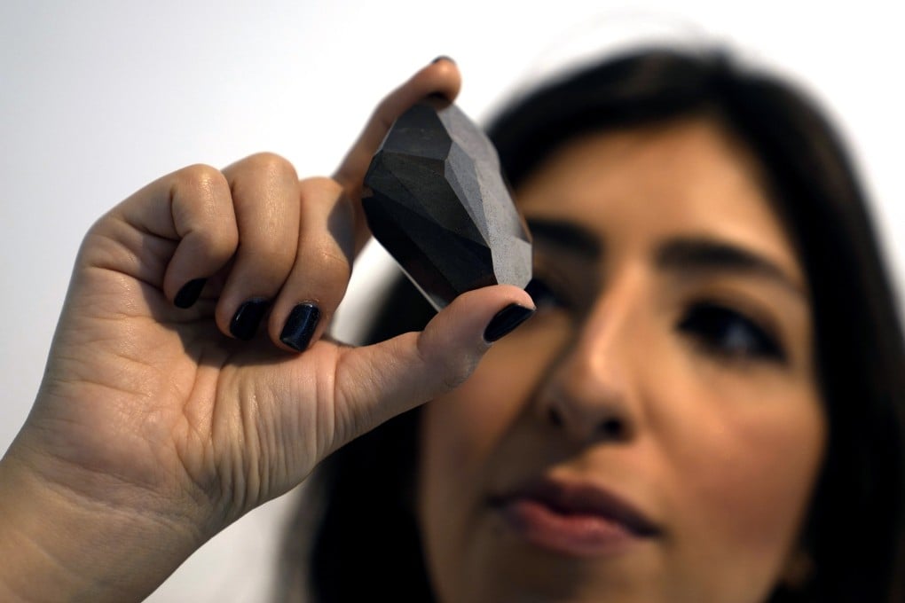A Sotheby’s Dubai employee presents a 555.55 carat black diamond “The Enigma” on Monday. Photo: AP