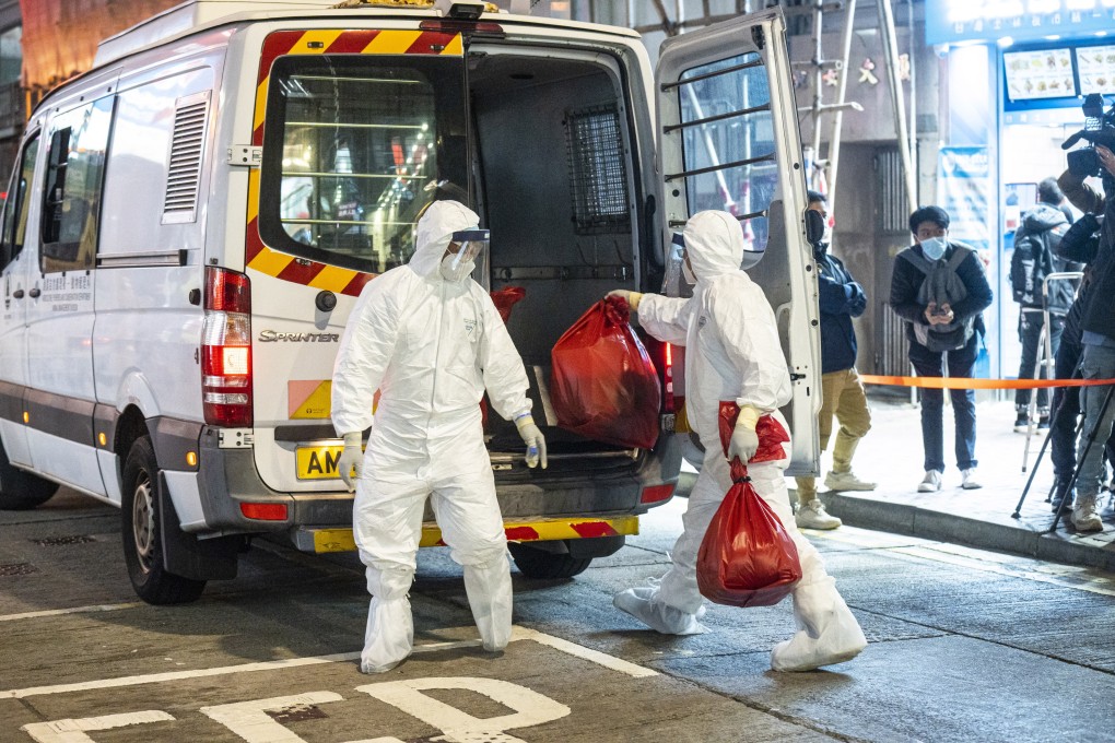 Hong Kong government workers remove small animals from a pet shop in Causeway Bay. Photo: Bloomberg