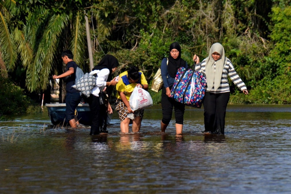 Residents walk in a flooded street in Kampung Semangat, Kuantan. Photo: Bernama/dpa