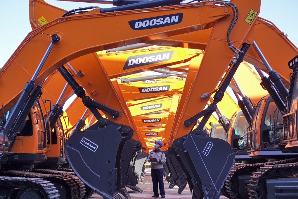 A worker checks excavators at a construction machinery company in Yantai, in China’s Shandong province, on January 17. In China, the release of fiscal stimulus is under way with clear support for infrastructure investment. Photo: Xinhua