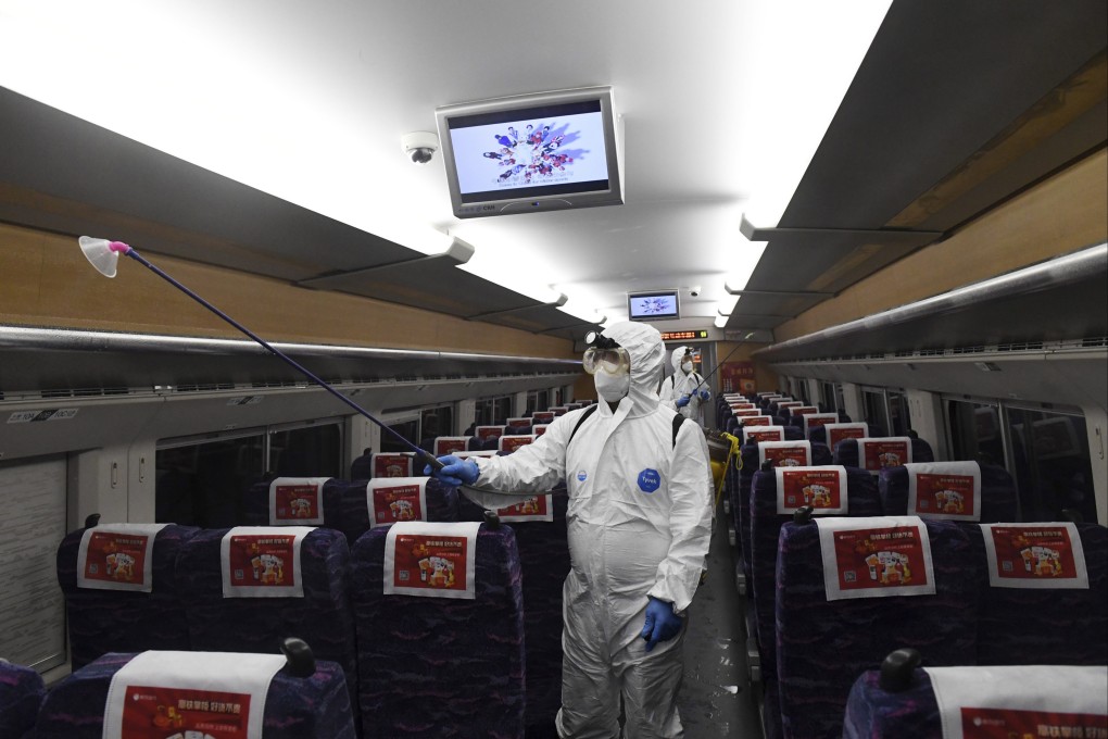 Workers in protective gear disinfect a train in southern China’s Guangxi Zhuang autonomous region. Photo: Xinhua via AP