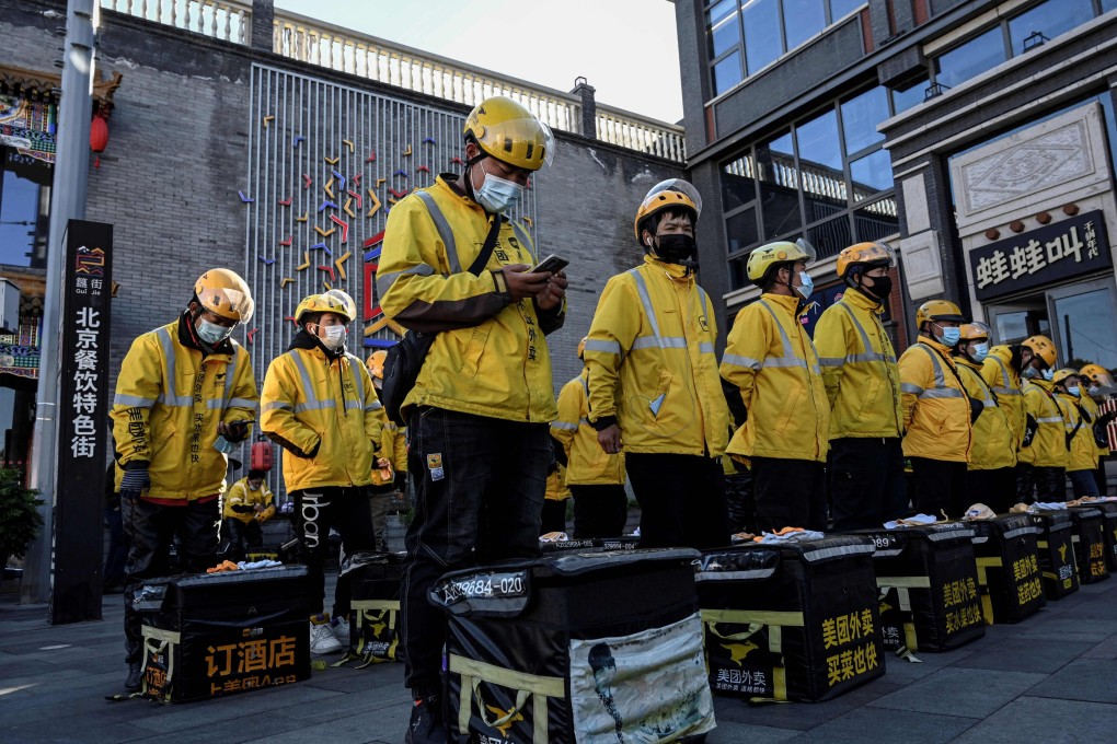 Food delivery drivers for online shopping platform Meituan standing in formation before starting their work along a street in Beijing on October 19, 2021. Photo: AFP