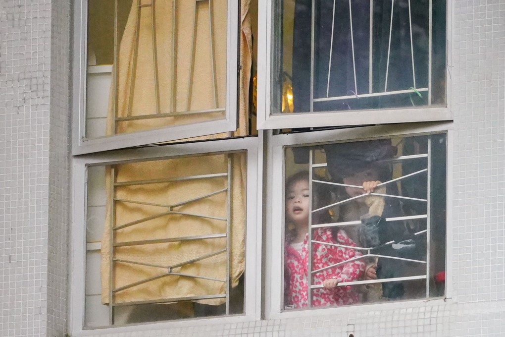 Girls peer out the window at Yat Kwai House, Kwai Chung Estate, in Kwai Tsing district on Saturday. Photo: Felix Wong