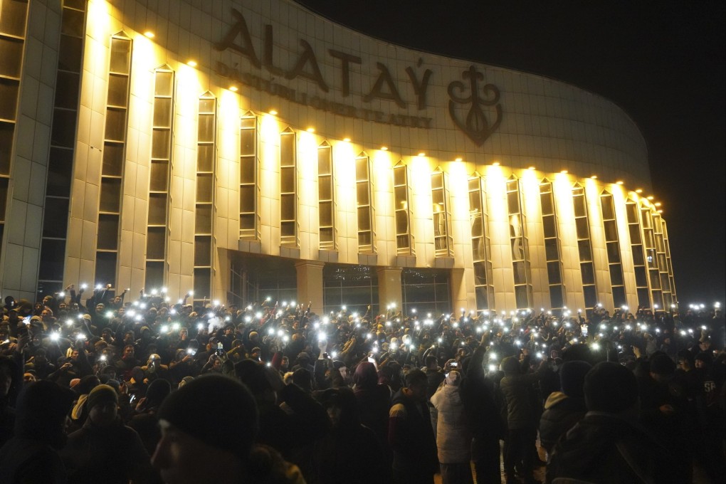 Protesters lit by their smartphones at the start of demonstrations in Almaty. Photo: AP