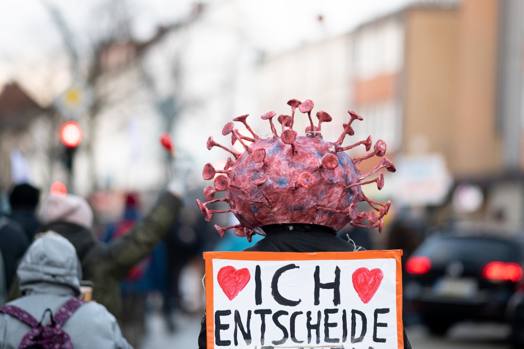 A protester wears headgear with a stylised virus on it during a demonstration against coronavirus policies in Hamburg, Germany on January 22. Photo: DPA