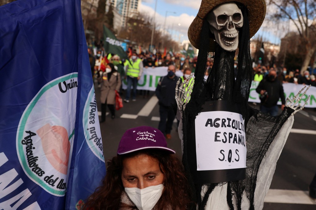 A woman holds a skeleton with a banner reading “Spanish farmer S.O.S”, as she takes part in a farmers’ protest in Madrid, Spain on January 23. Photo: Reuters