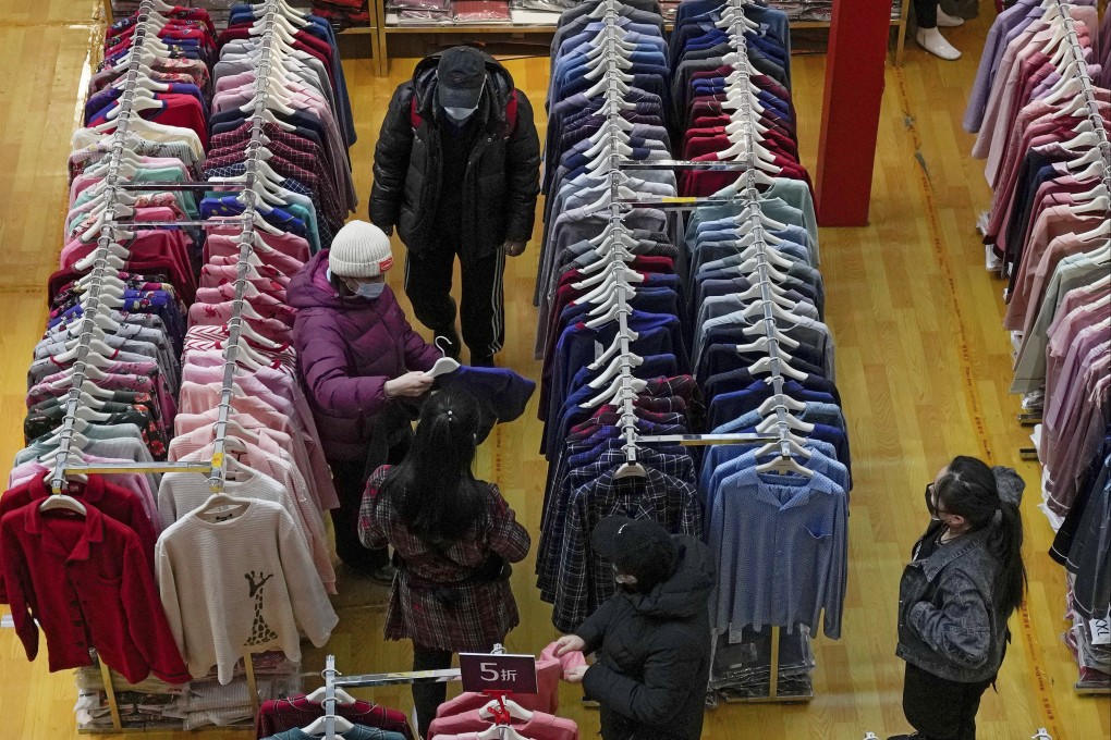 People shop for clothing during a promotional New Year sale at a mall in Beijing on January 16. Consumer demand needs a boost and there’s scope for the government to cut taxes in support. Photo: AP