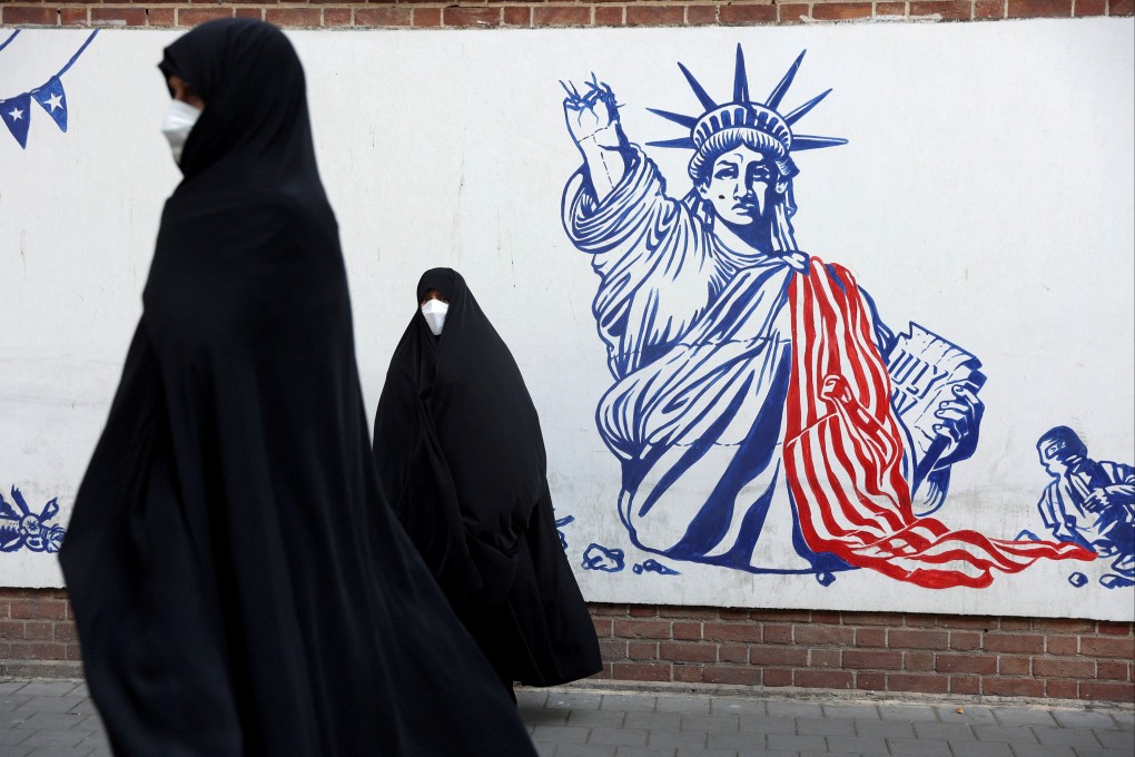 Demonstrators stand in front of a wall of the former US embassy in Tehran, Iran. Photo: Reuters