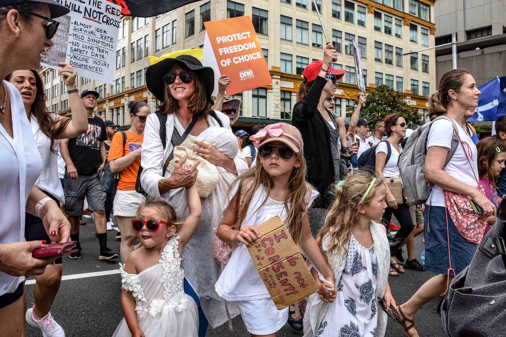 Protesters are seen with their children at an anti-vaccination rally in Sydney. Photo: dpa