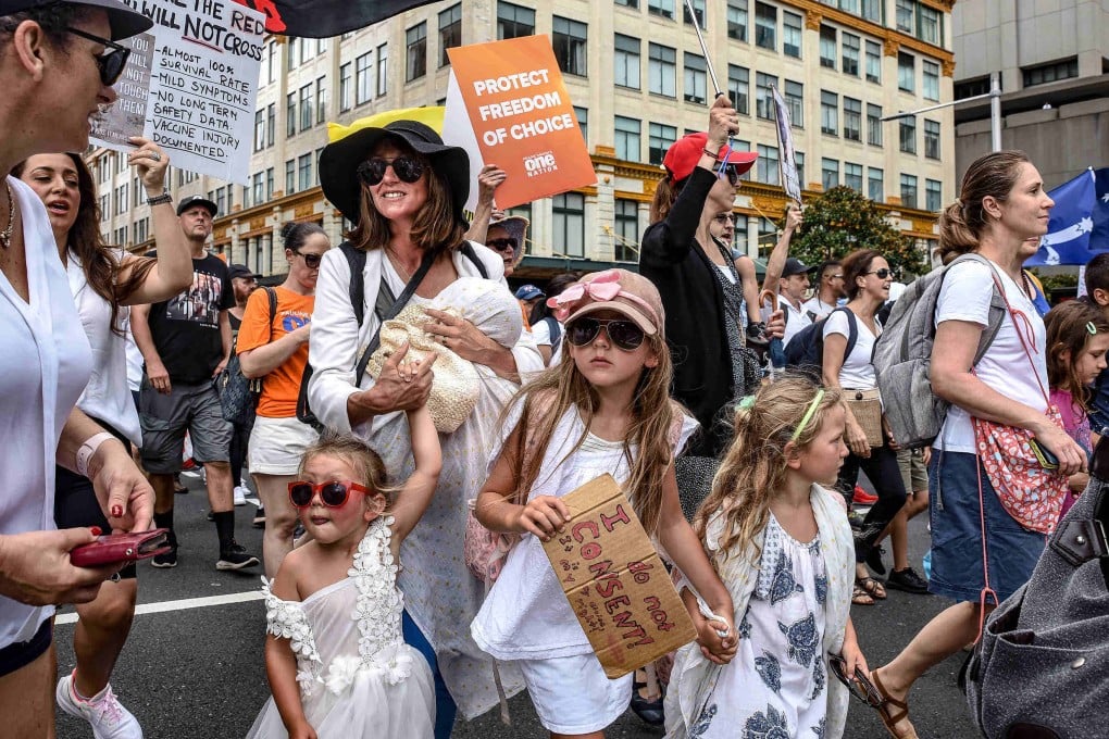 Protesters are seen with their children at an anti-vaccination rally in Sydney. Photo: dpa