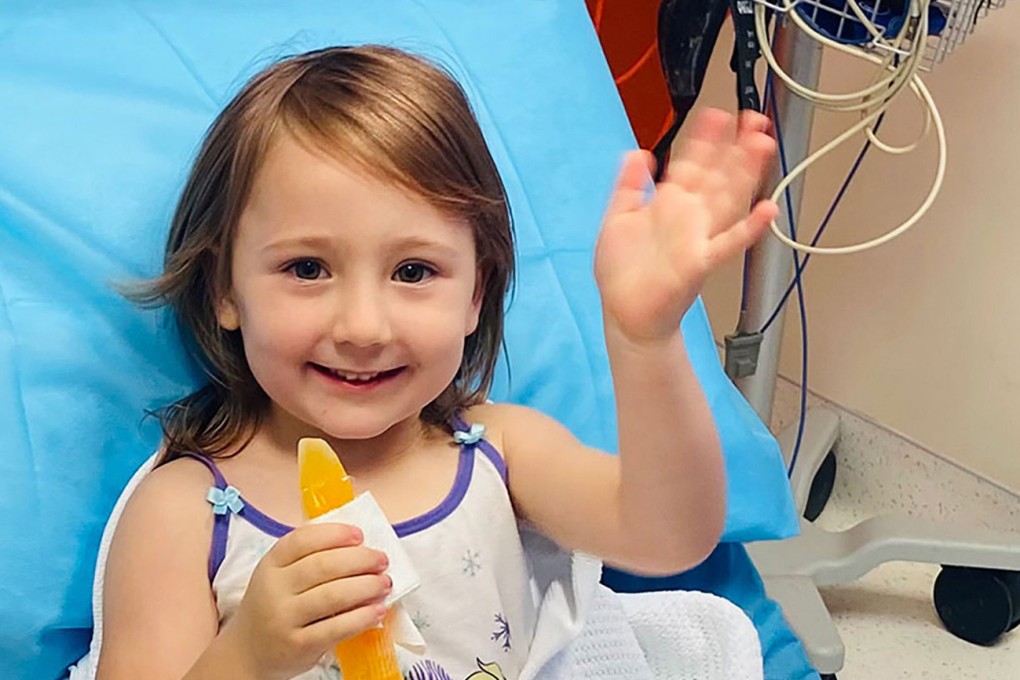 Cleo Smith, 4, waves as she sits on a hospital bed after her rescue. Photo: Western Australia Police via AP