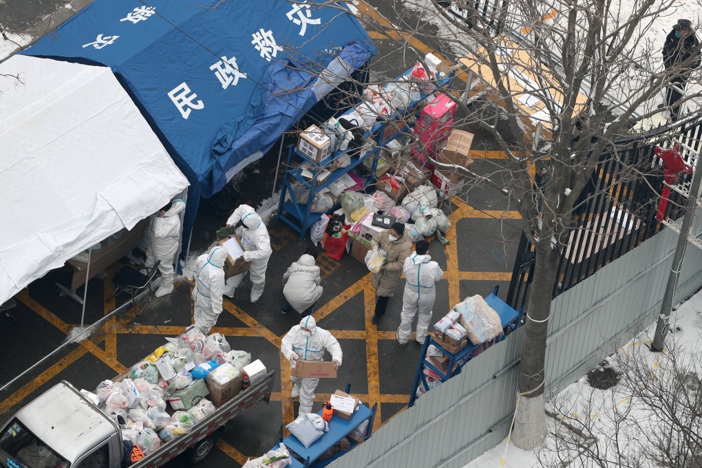 Workers in protective suits sort supplies to be delivered to residents at a compound under coronavirus lockdown in Beijing on Sunday. Photo: Reuters
