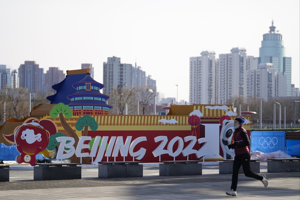 A woman jogs past an installation near the Beijing Olympic Park at the 2022 Winter Olympics on Tuesday. Taiwan has announced it would not send officials, only athletes, to the Games. Photo: AP Photo