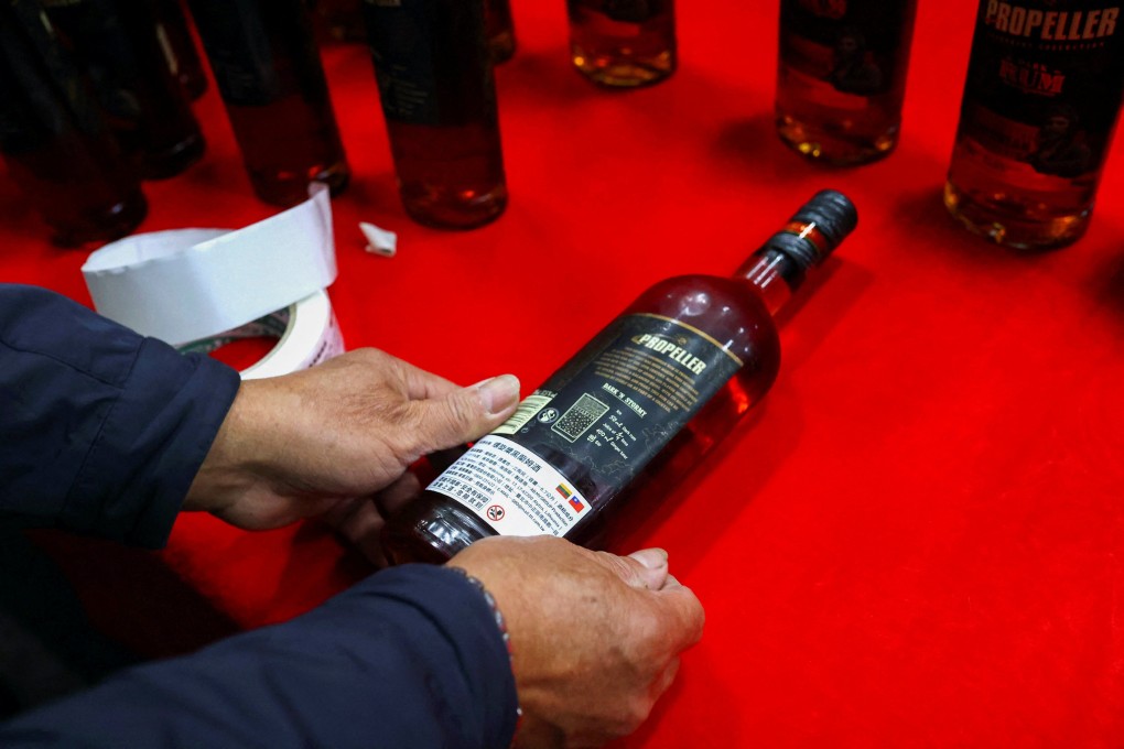 A staff member of Taiwan Tobacco and Liquor Corporation covers a simplified Chinese label with a traditional Chinese label on a bottle of rum from Lithuania at a cargo storage area, in Taoyuan, Taiwan, on January 22. Photo: Reuters