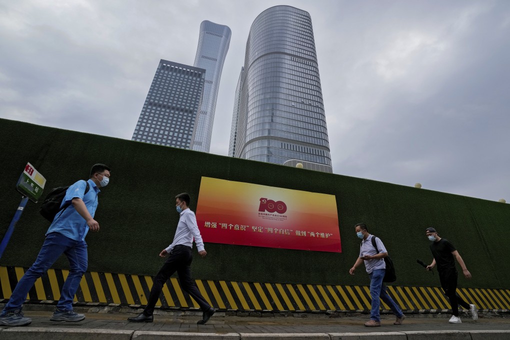 People walk past a poster marking the centenary of the founding of the Chinese Communist Party in Beijing. Photo: AP
