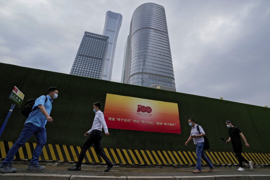 People walk past a poster marking the centenary of the founding of the Chinese Communist Party in Beijing. Photo: AP