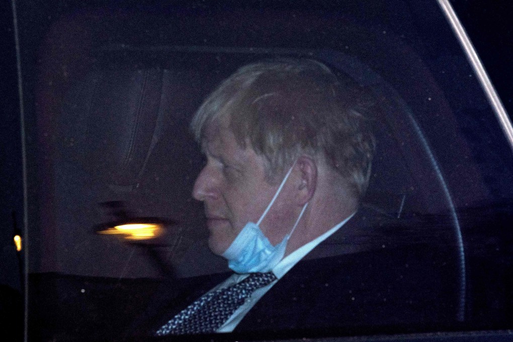 Britain’s Prime Minister Boris Johnson sits in the back of a car as he is driven away from the Houses of Parliament on Tuesday. Photo: AFP