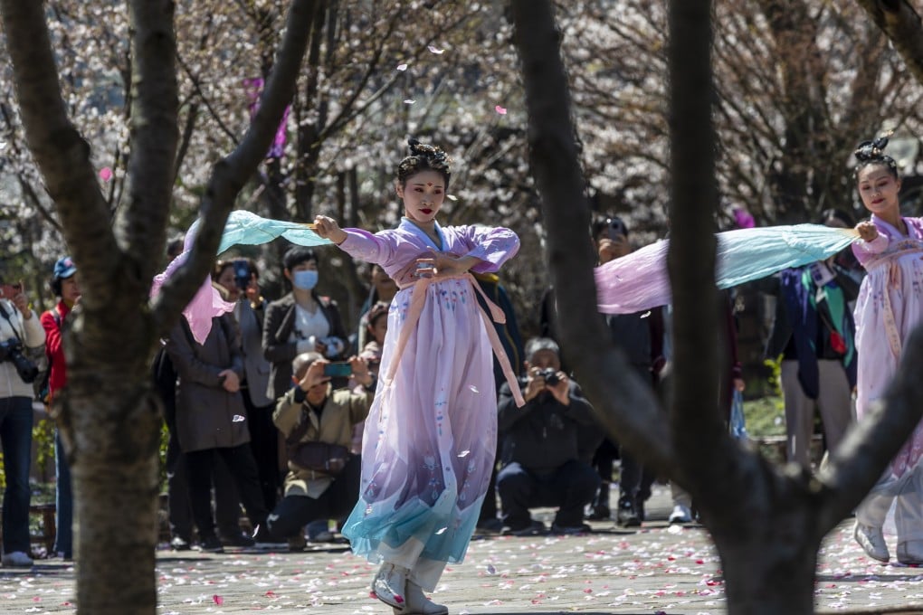 Women in traditional Chinese Hanfu attire dance for visitors to celebrate the Cherry Blossoms Festival in Nianhuawan, a town near Wuxi city, Jiangsu province, on March 22, 2021. Photo: EPA-EFE