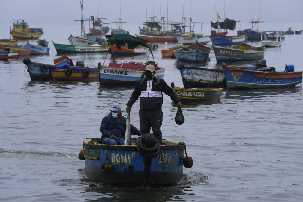 A fisherman holds a fish he caught in waters contaminated by an oil spill in Peru. Photo: AP