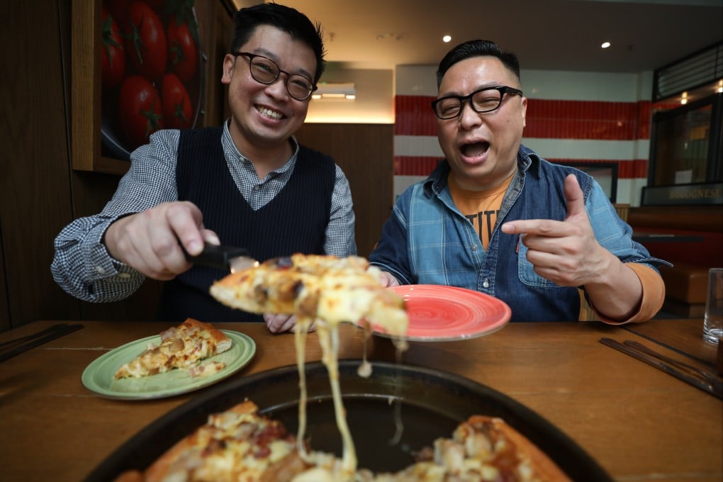 Blogger Gary Suen (left) and food writer Chan Chun-wai taste a Buddha Jumps Over the Wall pizza at Pizza Hut in Kennedy Town, Hong Kong. Photo: Xiaomei Chen