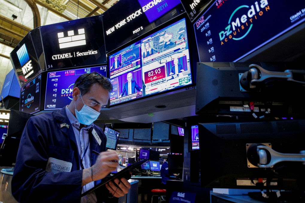 A trader works on the floor of the New York Stock Exchange as Federal Reserve chair Jerome Powell delivers remarks on screens on January 26. Photo: Reuters