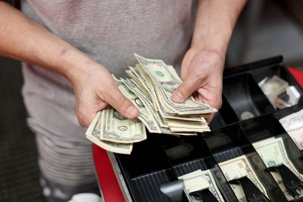 Edwin Lopez sorts money in the cash register at Frankie’s Pizza in Miami, Florida, on January 12. Inflation has soared to a 39-year high in the US. Photo: AFP