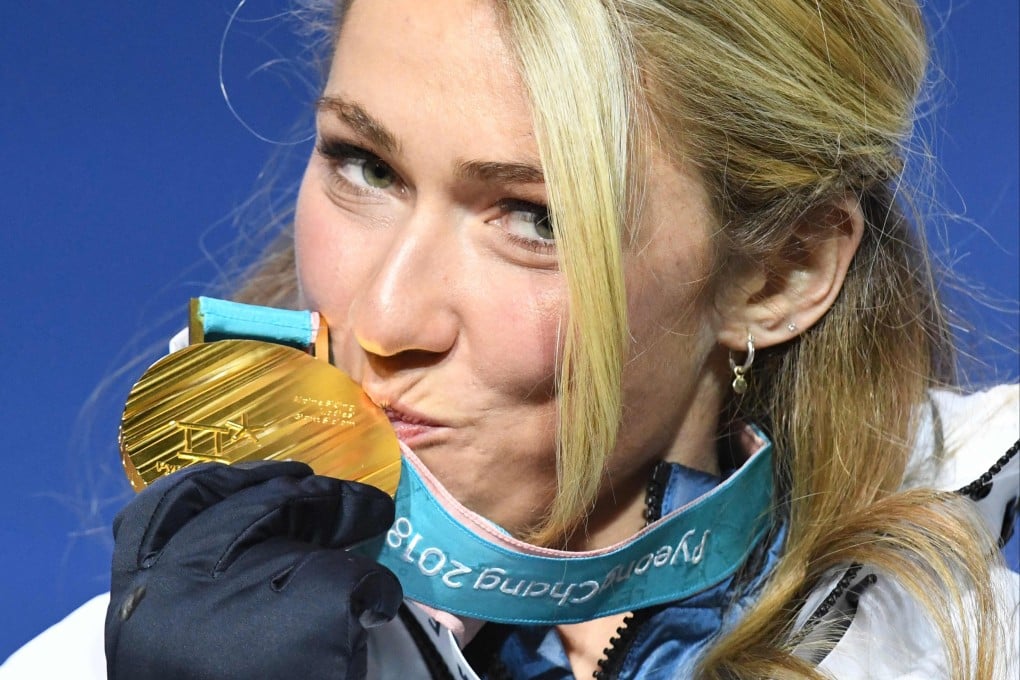 Mikaela Shiffrin kisses her giant slalom gold medal on the podium at the Pyeongchang Olympic Games. Photo: AFP