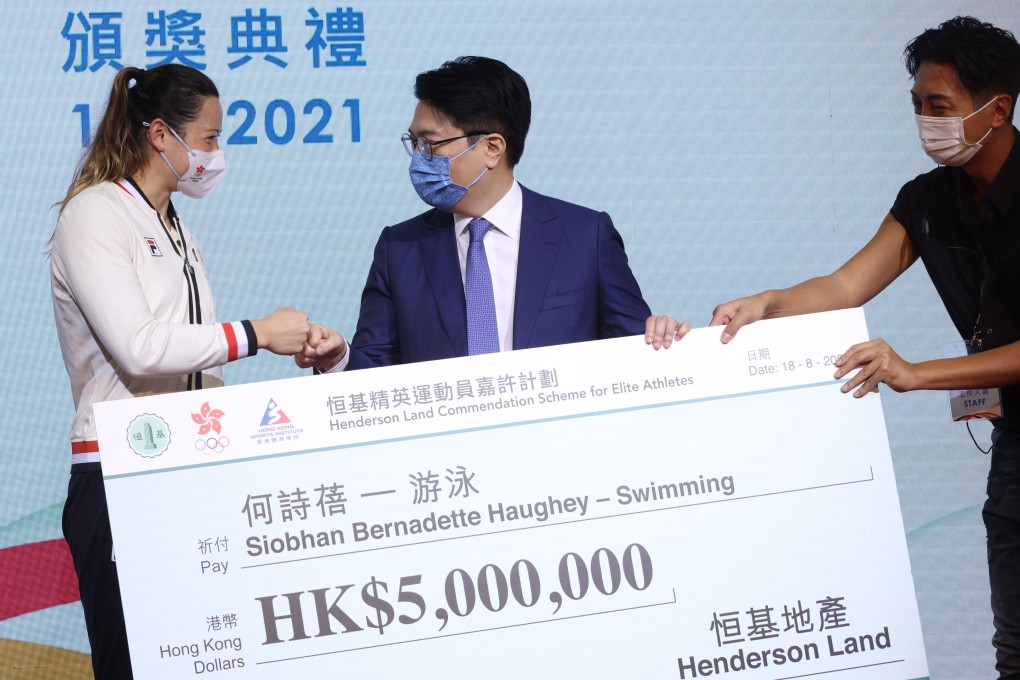 Siobhan Haughey (left) receives a cheque for HK$5 million from Henderson Land Group chairman Martin Lee Ka-shing (centre), after winning two silver medals the the Tokyo 2020 Olympic Games. Photo: May Tse