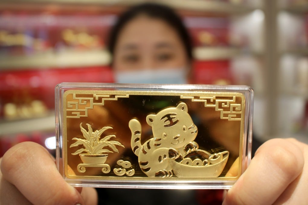 A staff member shows a gold bar featuring a tiger at a gold store in Suzhou, in China’s Jiangsu province. Photo: Getty Images