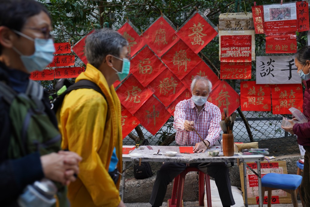 Calligrapher Dereck Kwok creates fai chun, a traditional Chinese decoration depicting messages of good luck and prosperity, ahead of the Lunar New Year in Sheung Wan. Photo: Sam Tsang