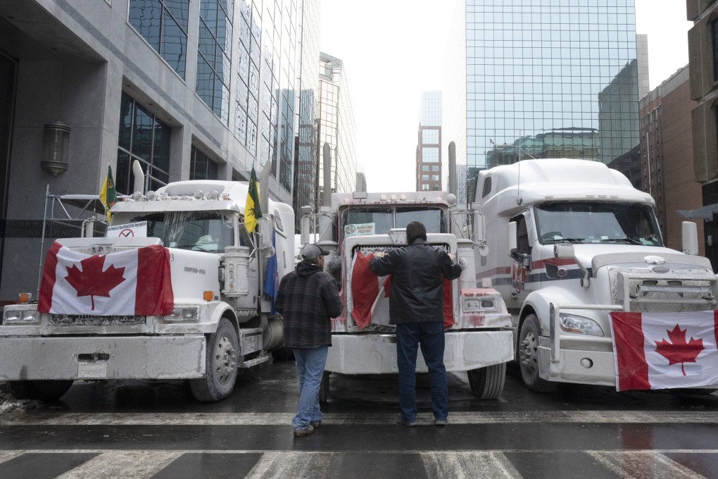 Truck drivers hang a Canadian flag on the front grill of a truck parked in downtown Ottawa, Ontario, near Parliament Hill. Photo: AP