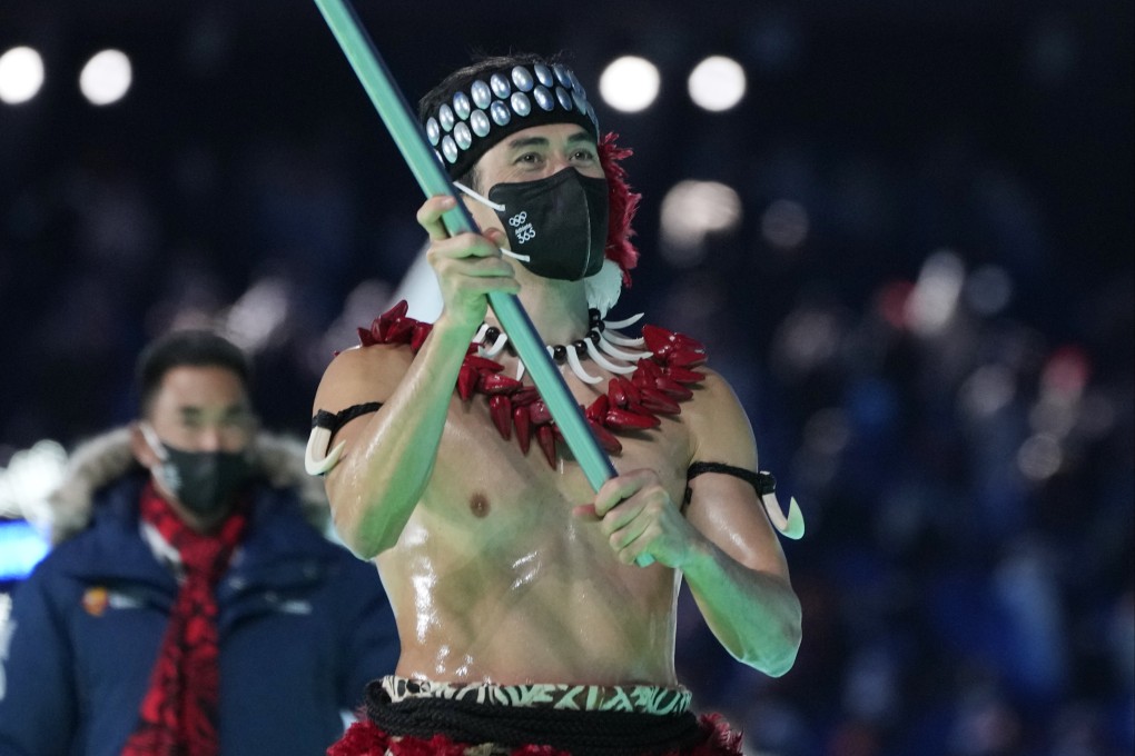 Nathan Crumpton, of American Samoa, carries his national flag into the stadium during the opening ceremony of the 2022 Winter Olympics in Beijing. Photo: AP/Natacha Pisarenko