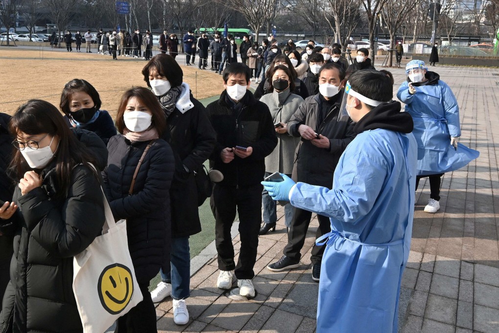Health workers in protective gear guide people queuing for Covid-19 testing in Seoul last month. Photo: AFP