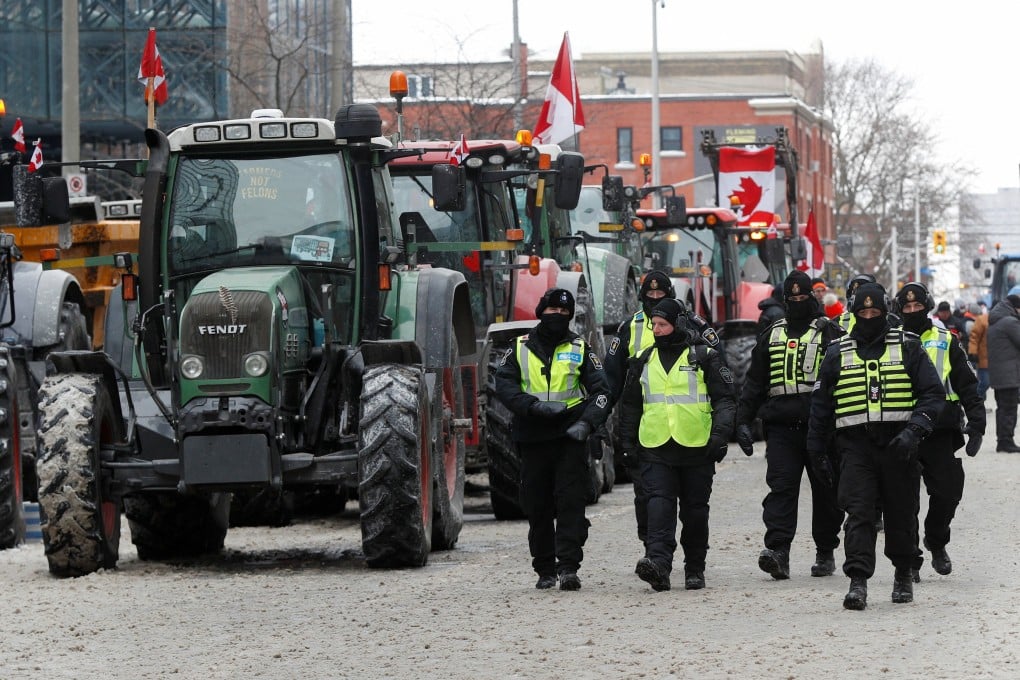 Ottawa police officers walk past tractors, as truckers protest Covid-19 restrictions. Photo: Reuters