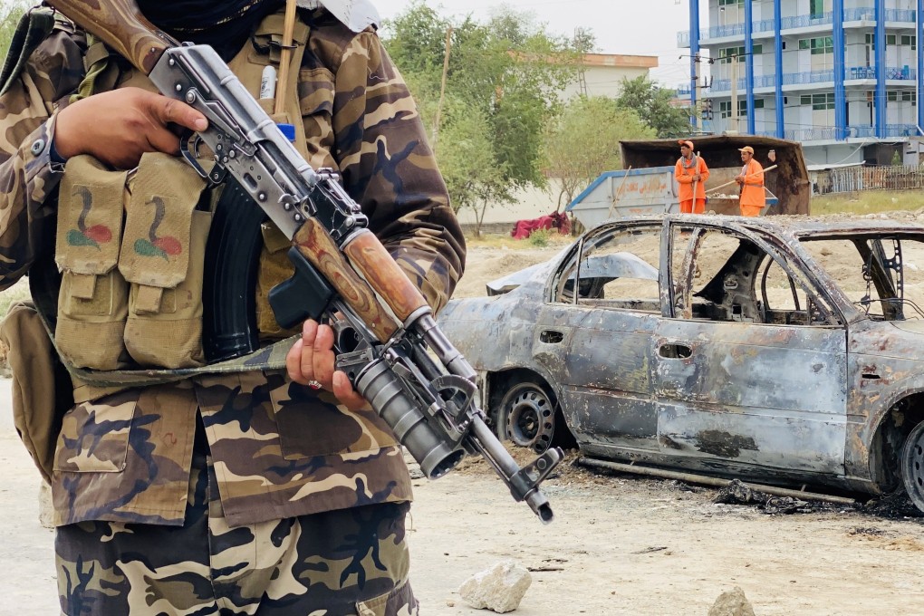 A member of the Taliban stands guard near a vehicle that was used to fire rockets at the Hamid Karzai International Airport in Kabul, Afghanistan in August. Photo: EPA-EFE