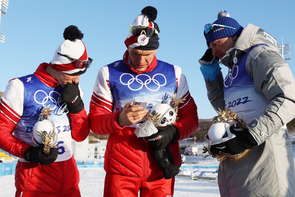 A Russian athlete look at his phone after the Men’s 15km+15km Skiathlon event at the Beijing Winter Olympics. Photo: EPA