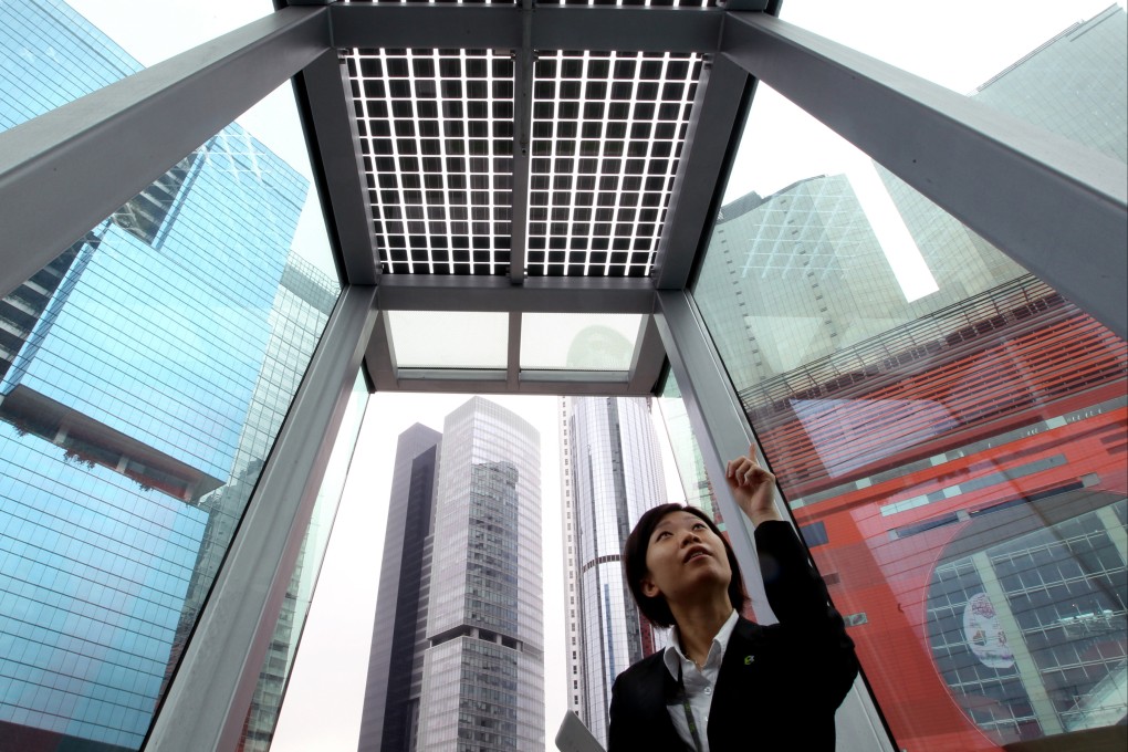 A customer service representative points to a solar panel at Hong Kong’s first zero carbon building, at 8 Sheung Yuet Road in Kowloon Bay, on its first day open to the public on December 17, 2012. Photo: Dickson Lee