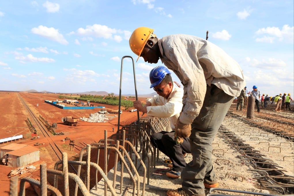 A Chinese engineer and a local construction worker work on a section of the Mombasa-Nairobi railway. Photo: Reuters