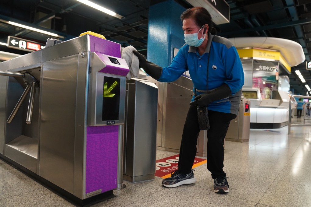 A cleaner disinfects a turnstile at Mei Foo MTR station. Photo: Sam Tsang