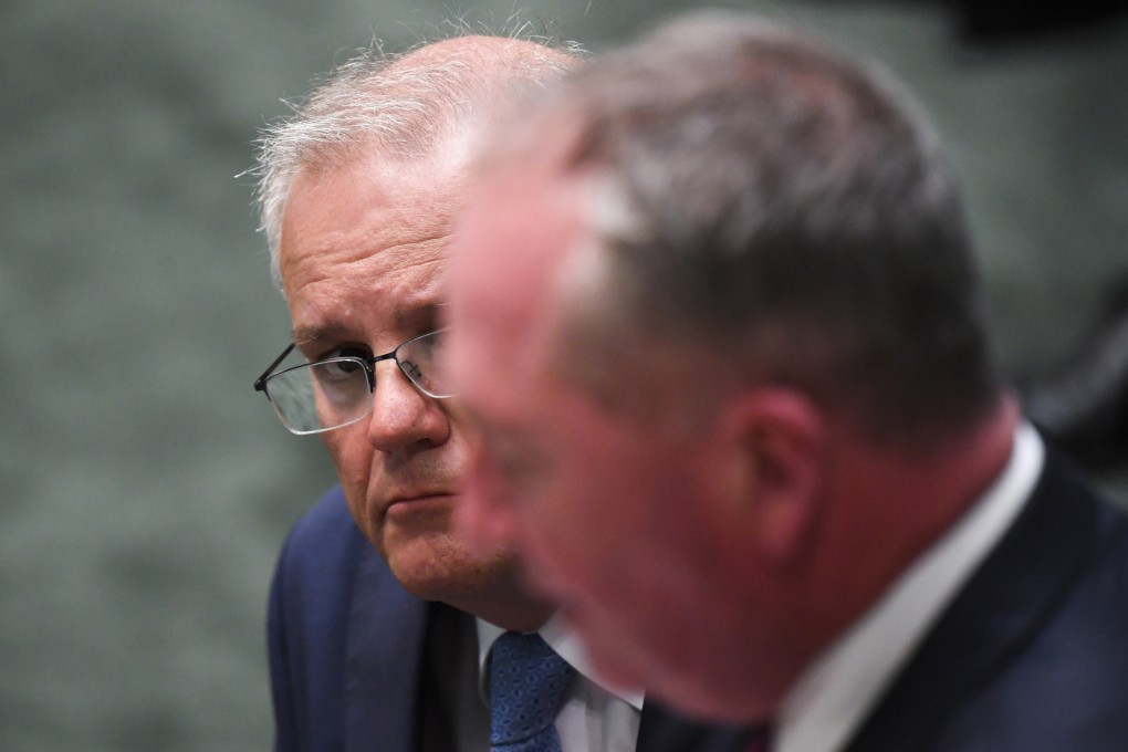 Australian Prime Minister Scott Morrison, in glasses, listens to Deputy Prime Minister Barnaby Joyce speak in Canberra on Tuesday. Photo: via AP