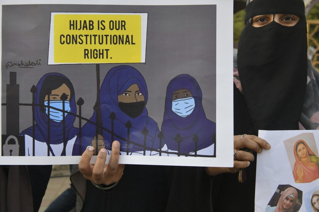 A Muslim woman holds a placard reading ‘Hijab is our constitutional right’ at a demonstration in Karnataka. Photo: AFP