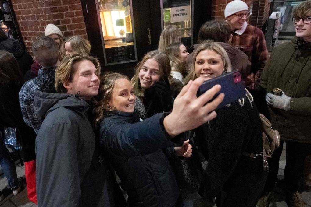 People take pictures of themselves as they queue outside a nightclub in Malmoe, Sweden, after the country lifted Covid-19 restrictions. Photo: AFP