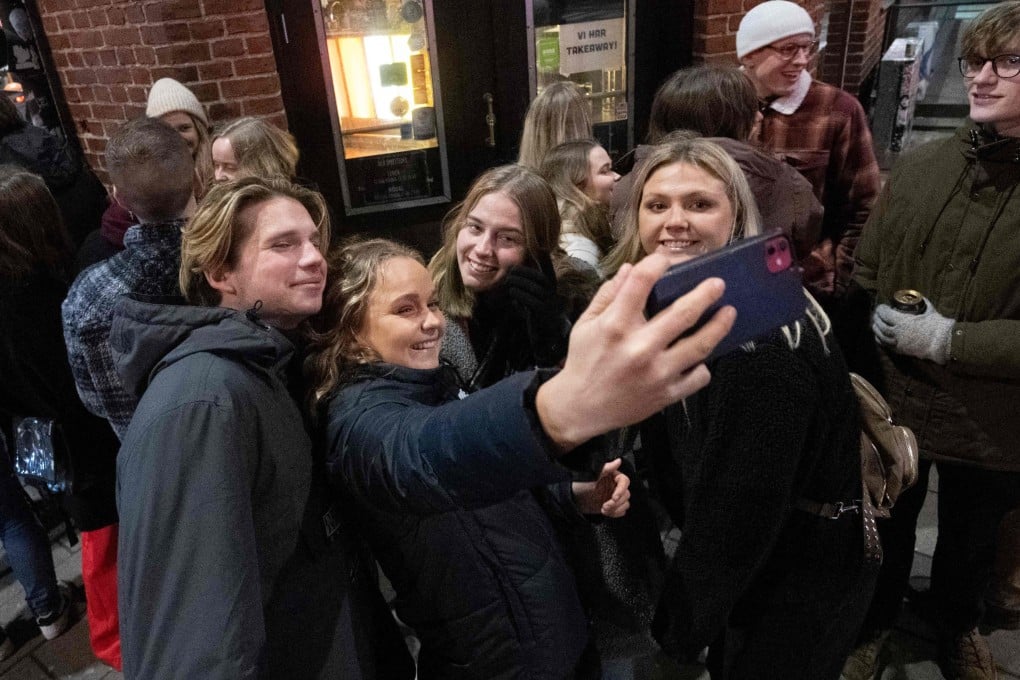 People take pictures of themselves as they queue outside a nightclub in Malmoe, Sweden, after the country lifted Covid-19 restrictions. Photo: AFP