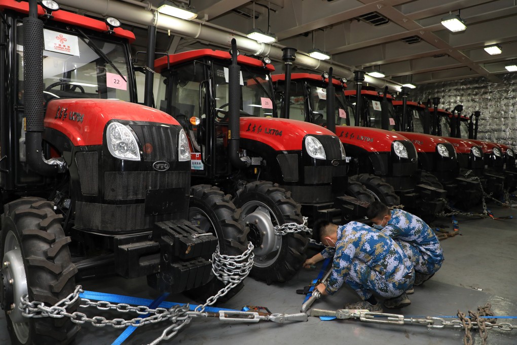 On January 30, PLA Navy personnel fasten tractors on a ship delivering relief supplies to Tonga. Weighing approximately 1,400 tonnes, the latest supplies include mobile homes, tractors, electricity generators, water pumps, water purifiers, food and medical supplies. Photo: Xinhua