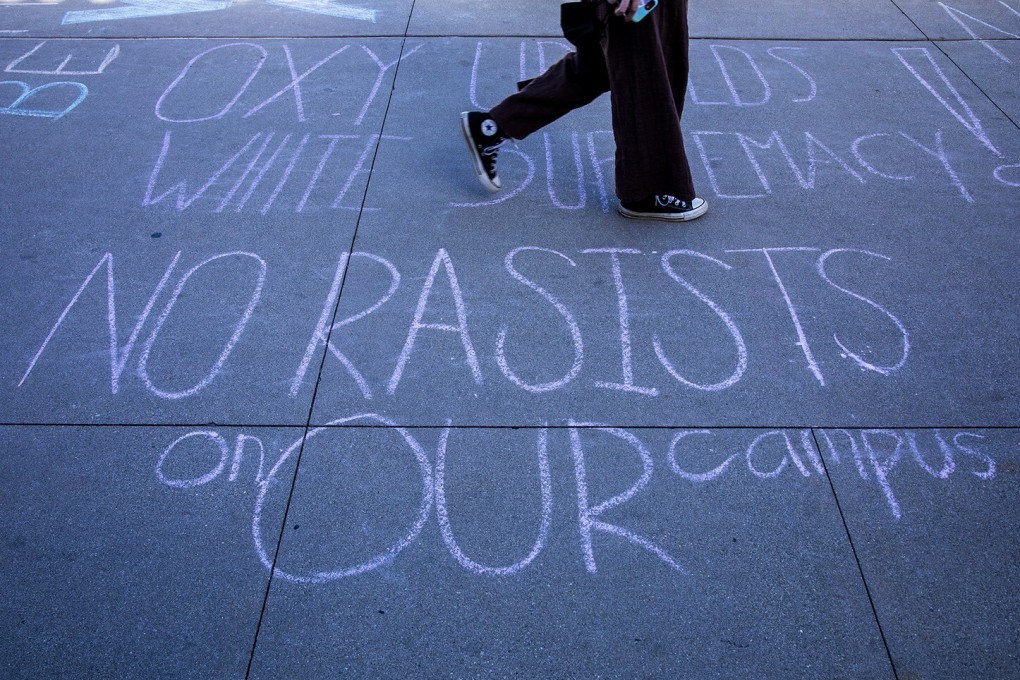 A student walks past a chalk message against racism on the campus of Occidental College on Tuesday. Photo: TNS
