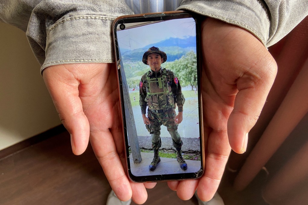 Kaung Thu Win shows a photograph of himself in Myanmar army uniform. Photo: Reuters