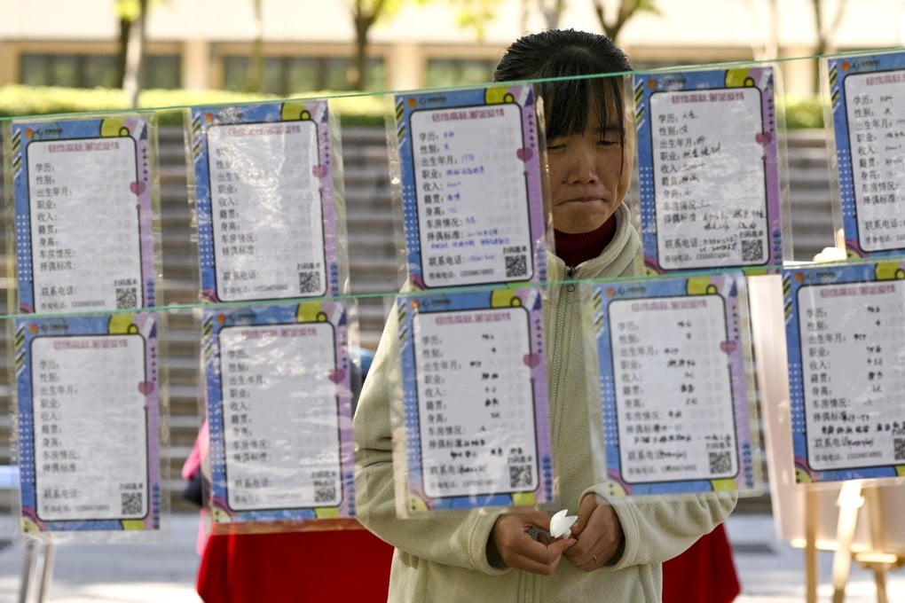 A woman inspecting rows of profiles strung up between trees during a matchmaking event in Jinan in eastern China’s Shandong province. Photo: AFP